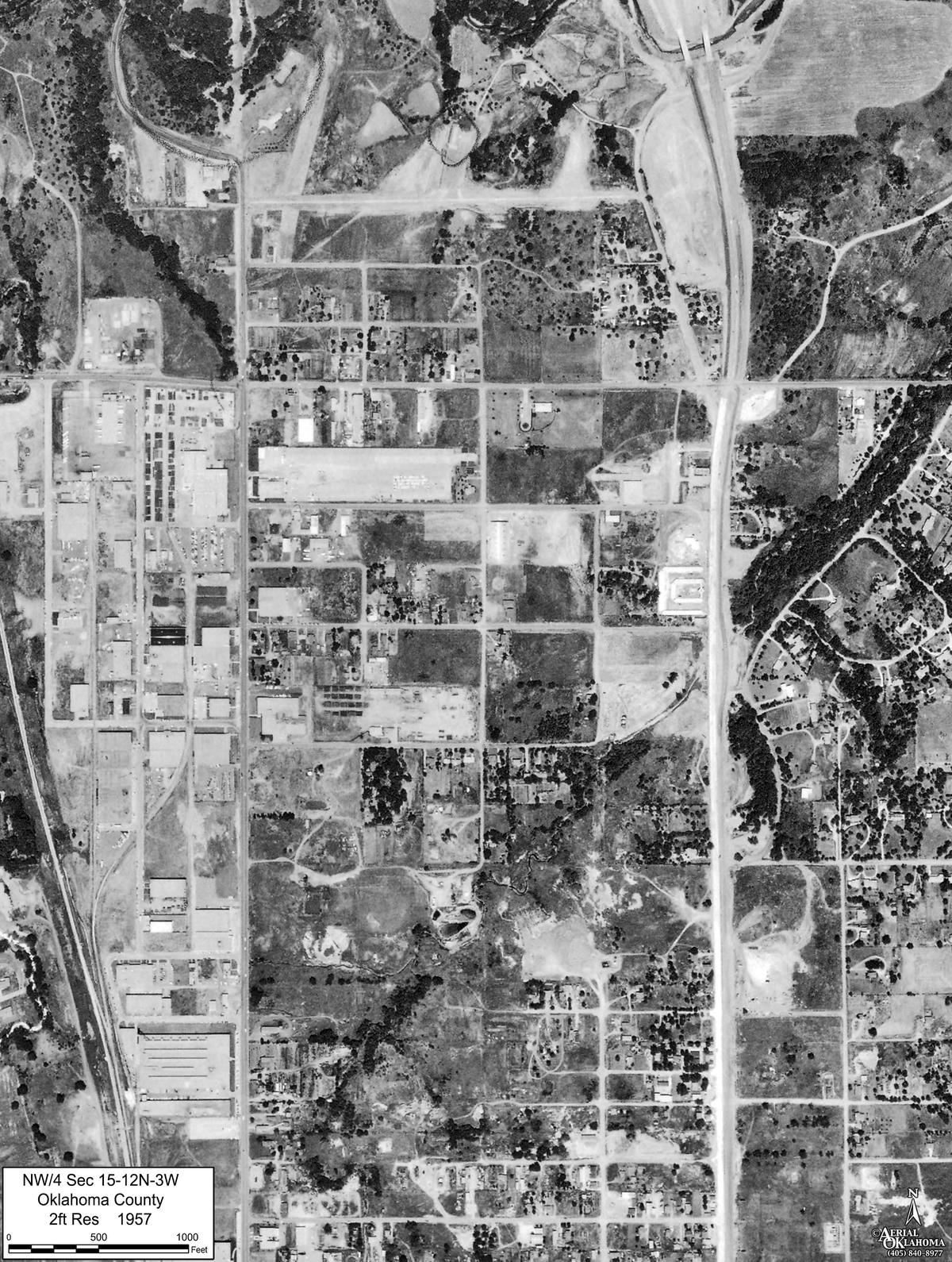 1957: a highway cut across the northeast corner and lots filling inside the grid