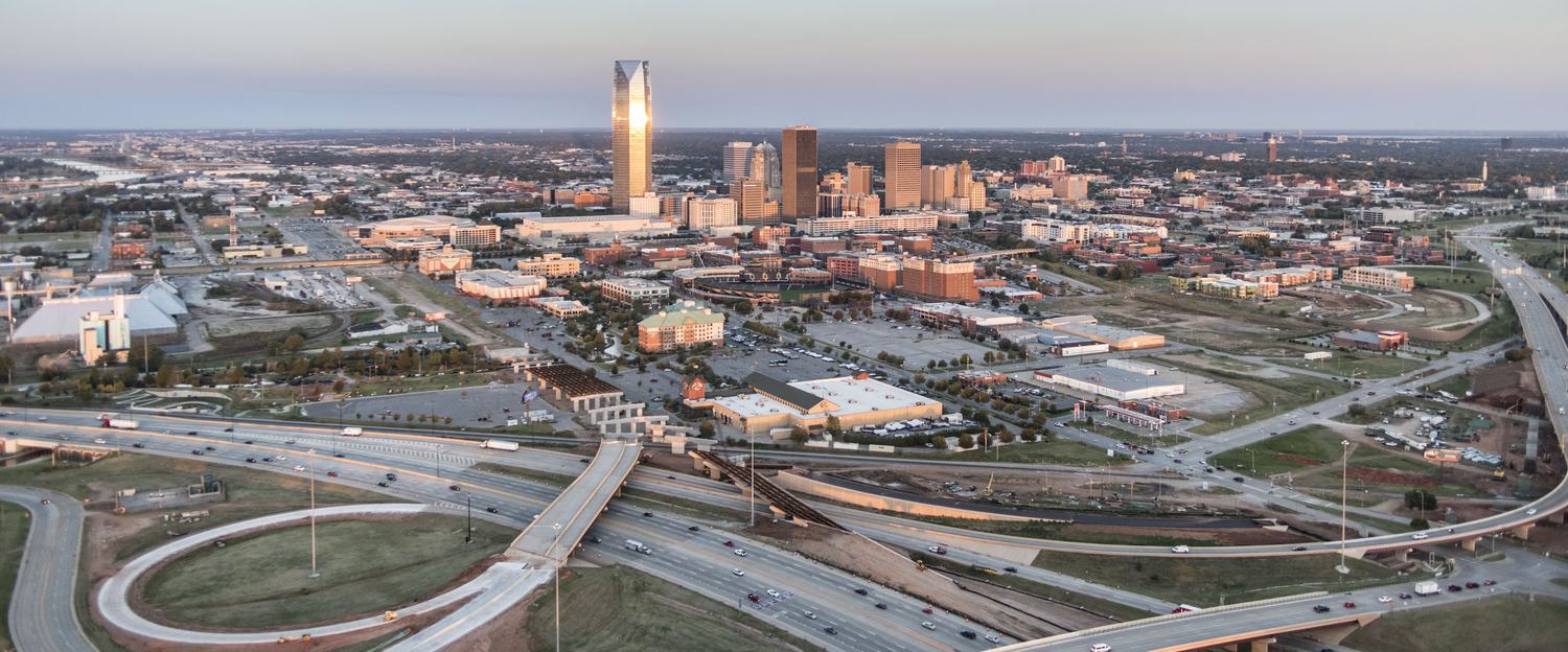 Highway interchange at golden hour, aerial oblique